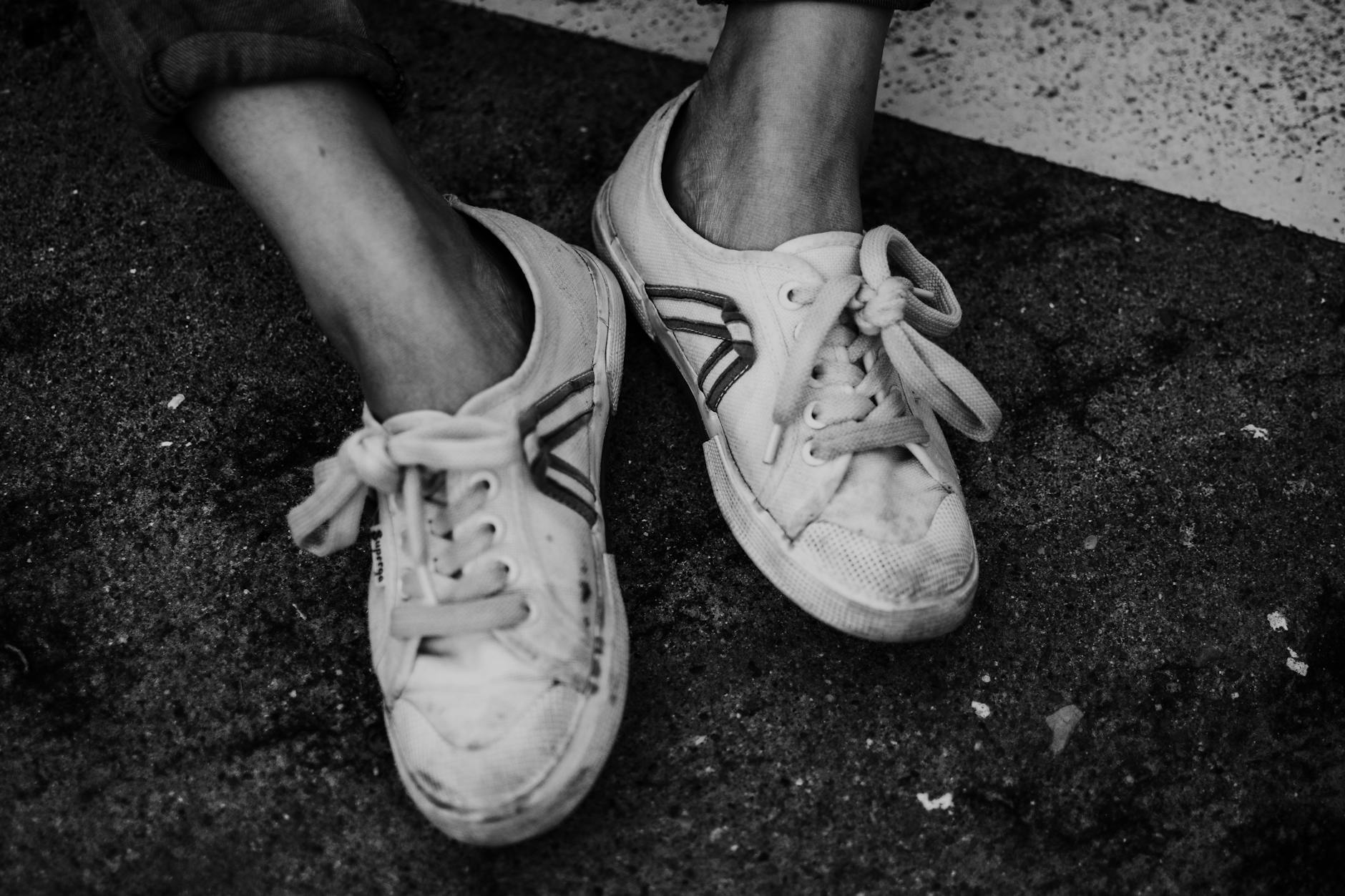 crop person with sneakers on pavement ground